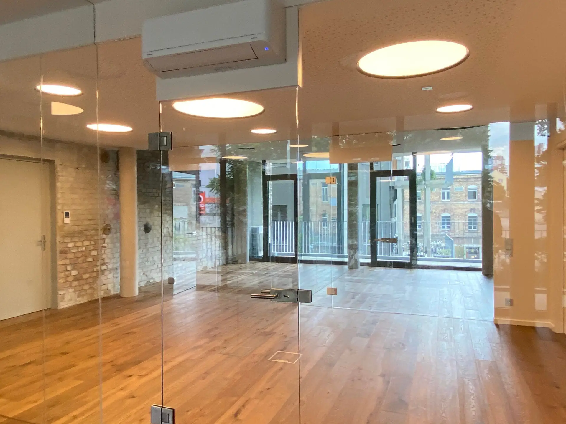 Büroloft in der Anker Brotfabrik, Innenansicht des Büros mit Glaswänden und Aussicht auf anderes Backsteingebäude.