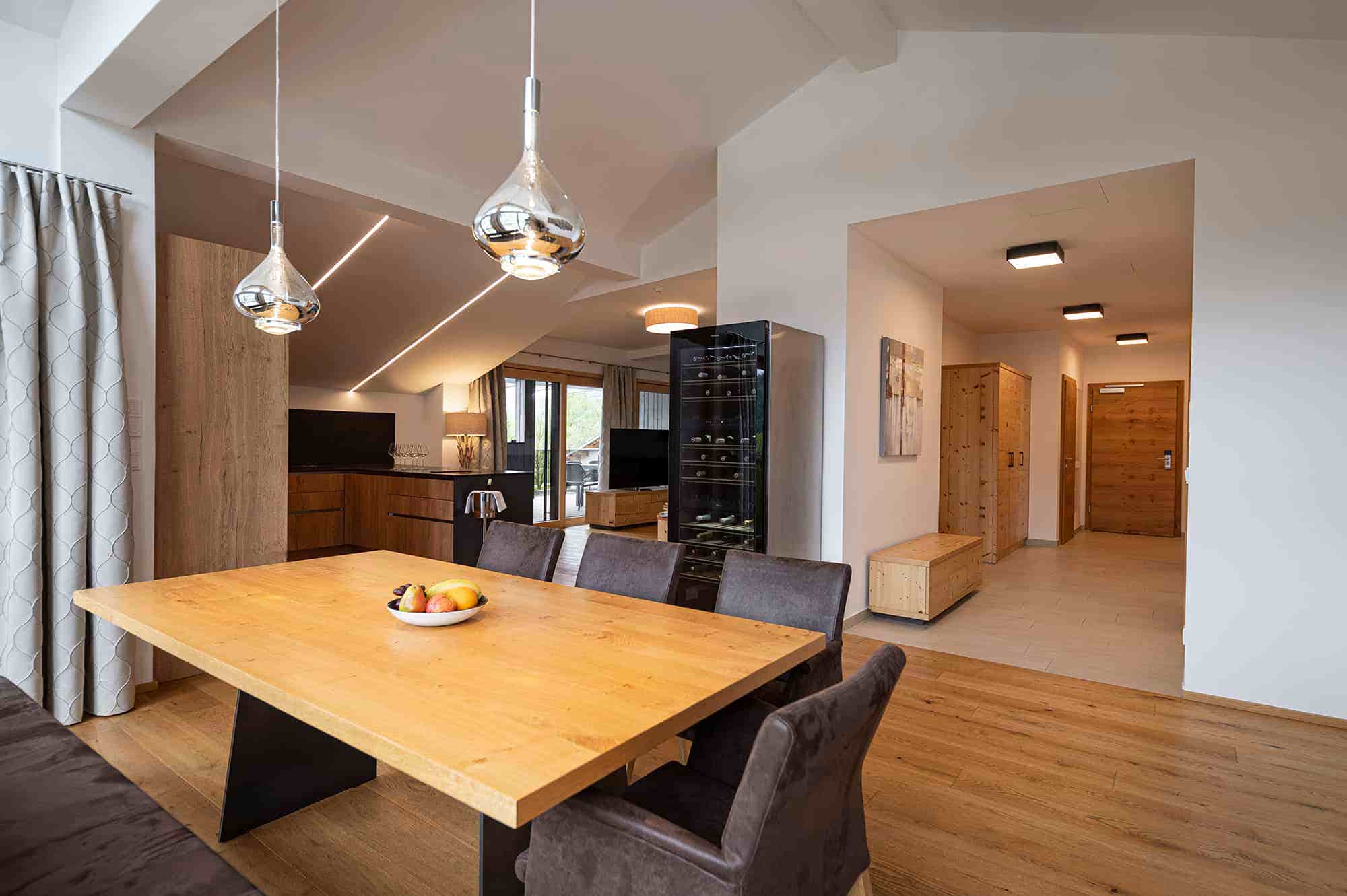 Lakeside Luxury Penthouse Großglockner, Blick auf Küche, mit großen Esstisch davor.
